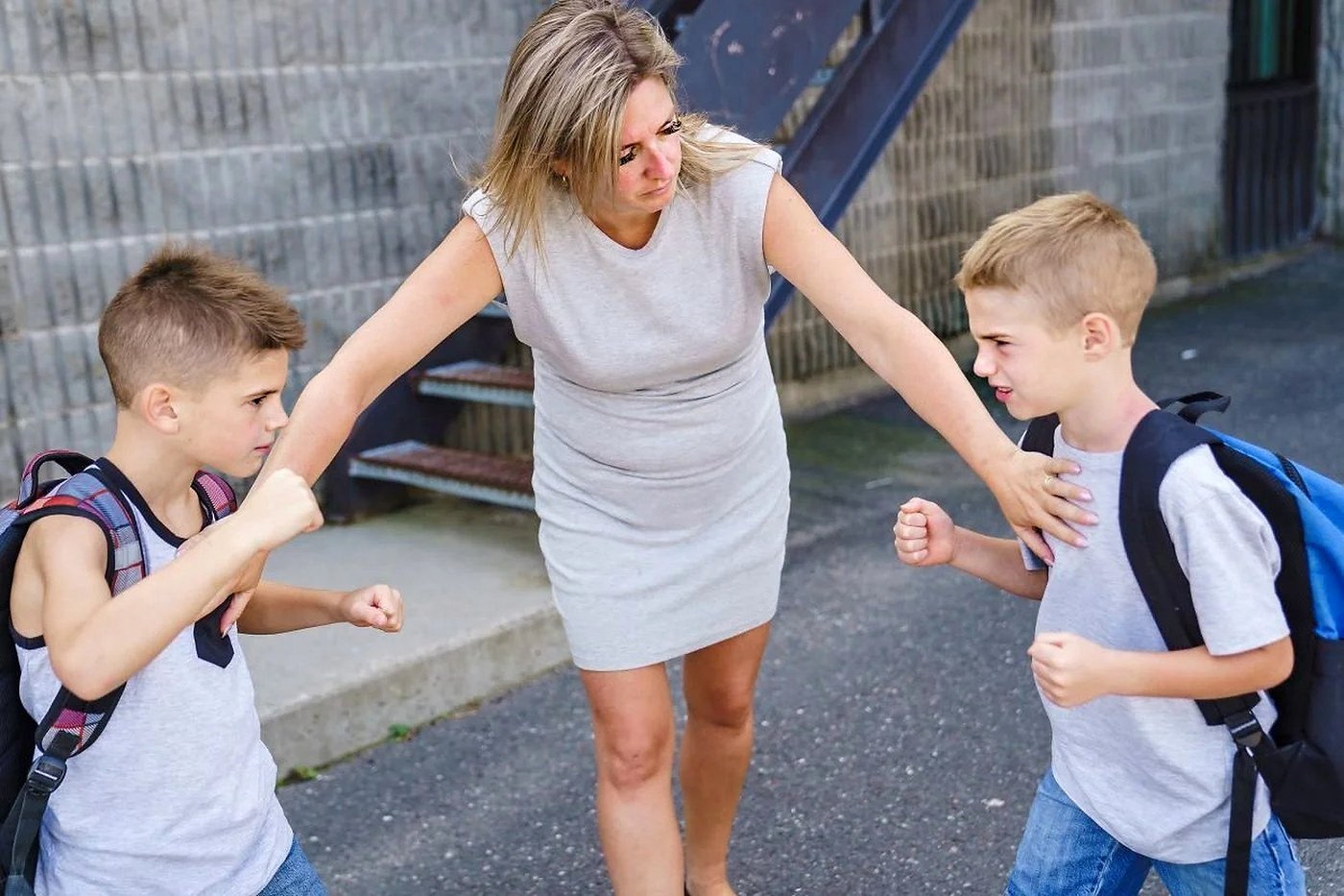 Teacher stepping in to separate two boys fighting at school — Positive Intervention training