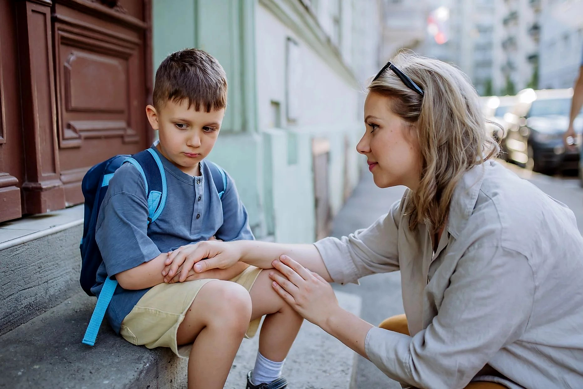 Adult crouching down to comfort a distressed child — Trauma Informed Practice